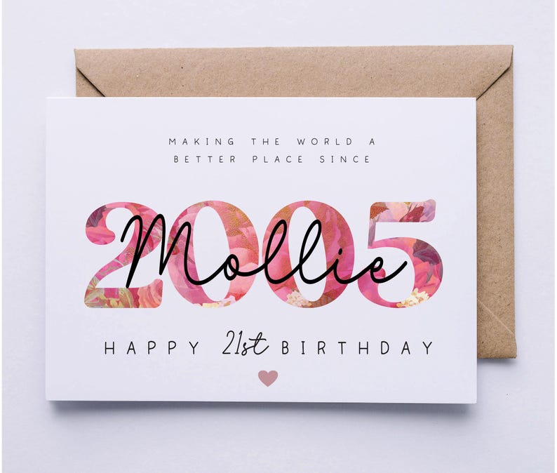 May include: A white birthday card with the text "Making the world a better place since 2005 Mollie Happy 21st Birthday" in black font. The numbers "2005" are filled with a floral pattern, and a pink heart is at the bottom.