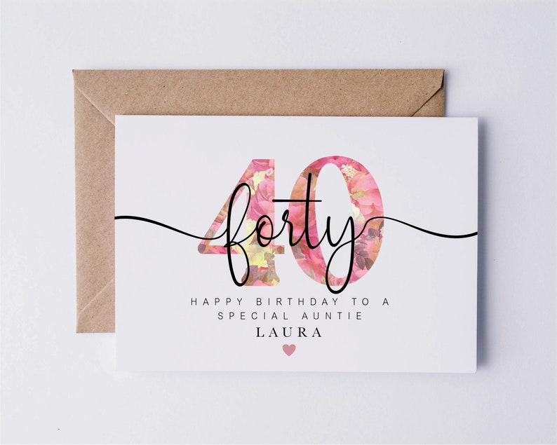 May include: A white card with a pink floral design in the number "40" with the text "forty" in black cursive script. The card reads "Happy Birthday to a Special Auntie Laura" with a pink heart.