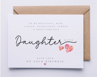 May include: A white card with black text that reads "To my beautiful, kind, caring, intelligent, strong & truly fabulous Daughter Katie" with two pink floral hearts. The text "With love on your birthday" is below the hearts with a small pink heart.