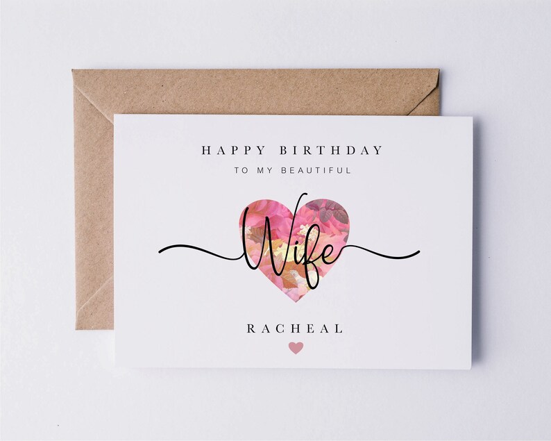 May include: A white card with the text "Happy Birthday to my beautiful Wife" and a pink floral heart with the word "Wife" inside. The name "Rachel" is printed below the heart.