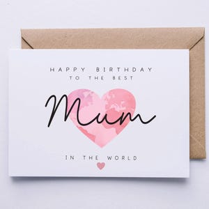 May include: A white card with the text "Happy Birthday to the Best Mum in the World" with a pink heart with a world map design.