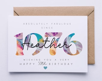May include: A white birthday card with a brown envelope. The card reads "Absolutely Fabulous Since 1976 Heather Wishing You a Very Happy 50th Birthday" with marbled numbers and a blue heart.