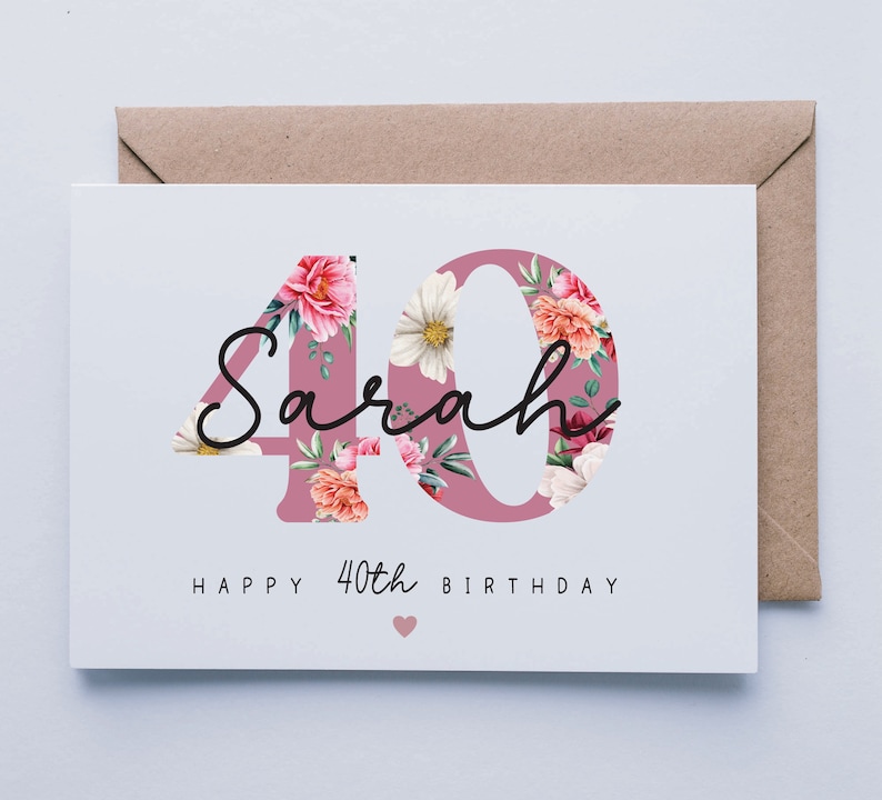 Puede incluir: Una tarjeta blanca con un dise&ntilde;o floral rosa con el n&uacute;mero 40 y el nombre Sarah. El texto "Happy 40th Birthday" est&aacute; impreso debajo del dise&ntilde;o floral.