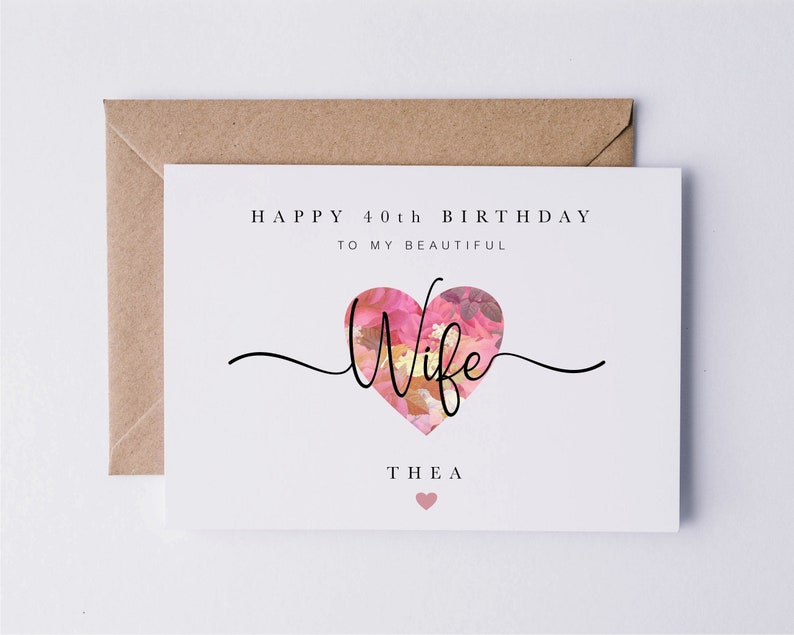 May include: A white card with the text "Happy 40th Birthday to my beautiful Wife Thea" with a pink floral heart graphic.