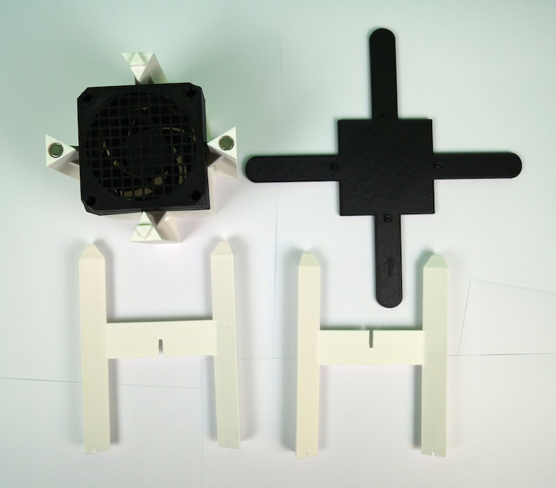 K&ouml;nnte beinhalten: Ein wei&szlig;er Plastik-Ventilatorst&auml;nder mit einem schwarzen Ventilator. Der St&auml;nder hat vier Beine und eine quadratische Basis. Der Ventilator hat einen schwarzen Grill und einen wei&szlig;en Rahmen.