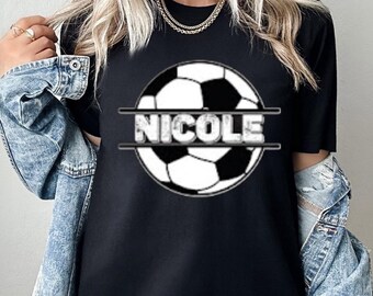 Può includere: Maglietta nera con una grafica di un pallone da calcio bianco e il nome "NICOLE" stampato in un font usurato.