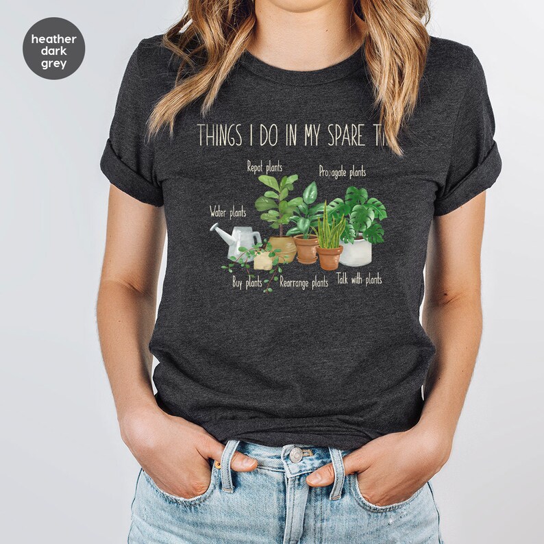 Peut inclure: Un t-shirt gris fonc&eacute; chin&eacute; avec le texte "THINGS I DO IN MY SPARE TIME" et un graphique de plantes en pot avec le texte "Repot plants", "Propagate plants", "Water plants", "Buy plants", "Rearrange plants", et "Talk with plants".