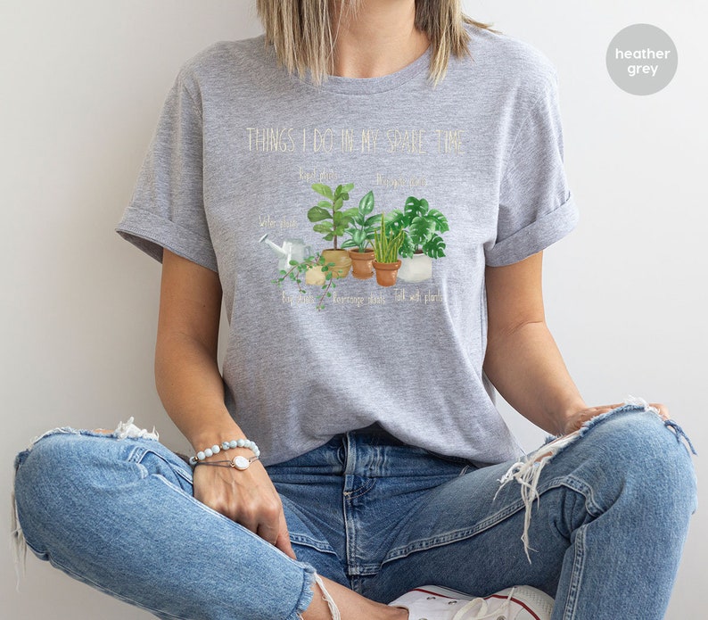 Peut inclure: T-shirt gris chin&eacute; avec le texte "Things I do in my spare time" et un graphique de plantes en pot. Le texte sous le graphique indique "Water plants, Repot plants, Arrange plants, Talk with plants."