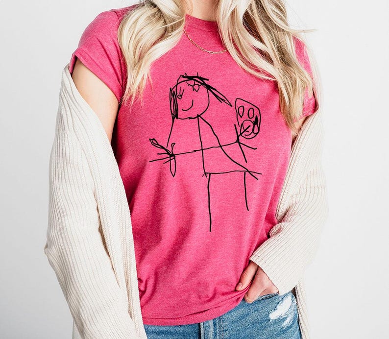 a woman wearing a pink shirt with a drawing on it