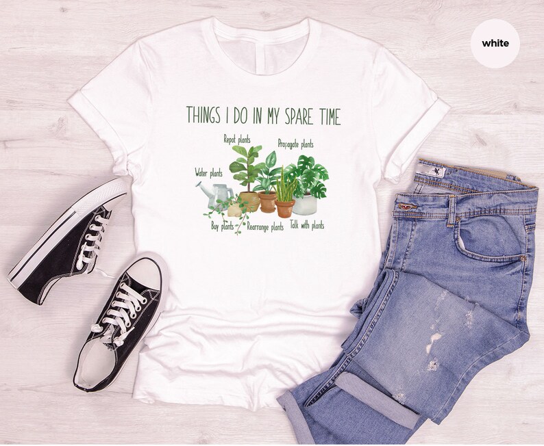 Peut inclure: T-shirt blanc avec un graphique de plantes et le texte "THINGS I DO IN MY SPARE TIME" avec les mots "Repot plants", "Propagate plants", "Water plants", "Buy plants", "Rearrange plants", et "Talk with plants" &eacute;crits sous le graphique.