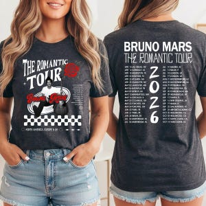 May include: Dark gray t-shirt featuring the text "THE ROMANTIC TOUR" and "Bruno Mars" with a graphic of a rose and a guitar. The back of the shirt displays tour dates for 2026.