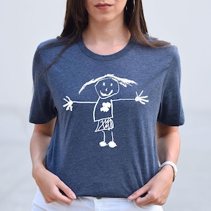a woman wearing a t - shirt with a drawing of a girl holding an umbrella