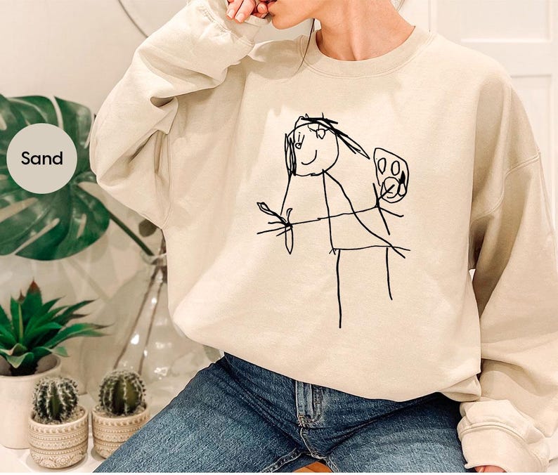 a woman wearing a sweatshirt with a drawing on it