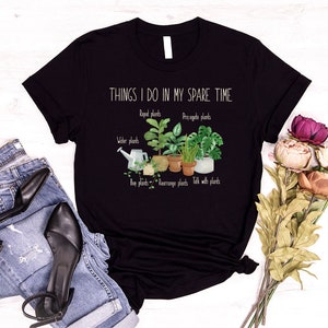 Peut inclure: T-shirt noir avec le texte "THINGS I DO IN MY SPARE TIME" et un graphique de plantes en pot avec le texte "Repot plants", "Propagate plants", "Water plants", "Buy plants", "Rearrange plants", et "Talk with plants".