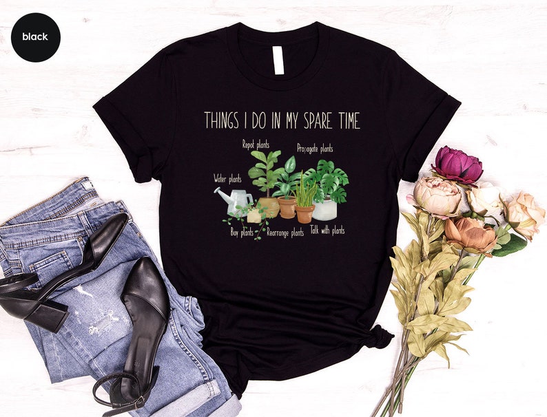 Peut inclure: T-shirt noir avec le texte "THINGS I DO IN MY SPARE TIME" et un graphique de plantes en pot avec le texte "Repot plants", "Propagate plants", "Water plants", "Buy plants", "Rearrange plants", et "Talk with plants".