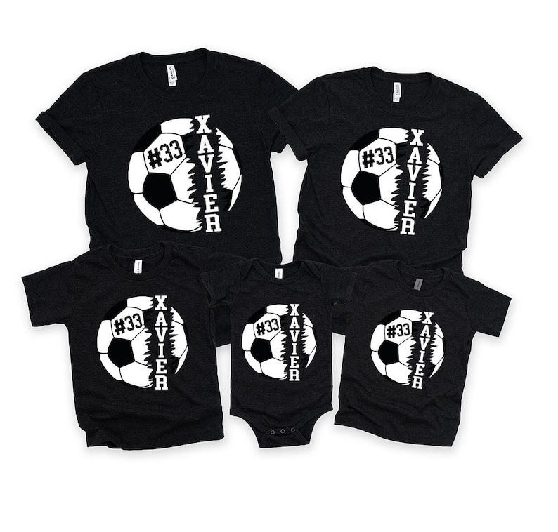 May include: Four black t-shirts featuring a white football design. The football is split in half with the word "XAVIER" written vertically on one side and the number "#33" on the other side.