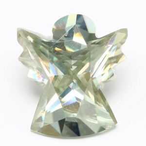 May include: A clear, faceted, green angel-shaped crystal with iridescent rainbow reflections.