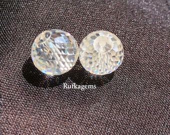 May include: Two clear, faceted crystal ball-shaped objects. The crystals are round with a cut pattern that reflects light. The text "Rufkagems" is printed in white on the dark background.