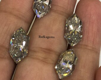 May include: Four marquise-cut, faceted, colorless gemstones with high brilliance and light reflection, arranged in a cluster. The text 'Rufkagems' is printed in black in the center of the arrangement, positioned between the four individual stones.