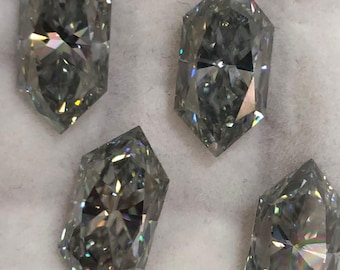 May include: Four loose, faceted, marquise-cut gemstones with a grey, metallic luster and high brilliance. Each stone features a pointed, elongated hexagonal shape with intricate internal facets that reflect light. The text Rufkagem is visible.