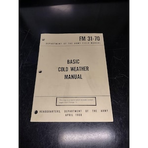 May include: A black and white Army Field Manual titled "Basic Cold Weather Manual" with the text "FM 31-70" and "Department of the Army" printed on the cover. The manual was published in April 1968.