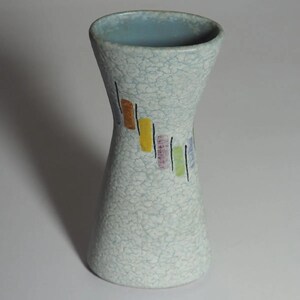 May include: A ceramic vase with an hourglass shape and a light blue crackle glaze finish. The exterior features a diagonal pattern of small, colorful rectangular blocks in orange, yellow, purple, green, and blue, each accented by a thin black line.