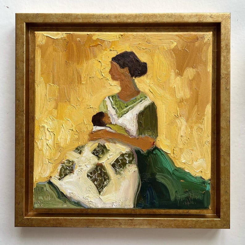 May include: Oil painting of a mother and child in a gold frame. The mother is wearing a green and white dress, holding a baby wrapped in a blanket. The background is a textured yellow.