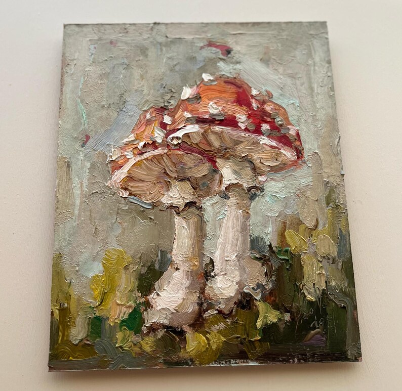 May include: An oil painting on a rectangular canvas featuring two mushrooms with red caps and white spots. The stems are painted in shades of cream and beige. The background consists of textured, muted gray and green brushstrokes.