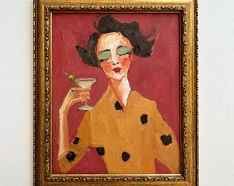 Puede incluir: Una pintura al óleo en un marco dorado que representa a una persona con cabello oscuro y sombra de ojos verde, vistiendo una camisa amarilla mostaza con lunares negros. La persona sostiene una copa de martini con una aceituna sobre fondo rojo.
