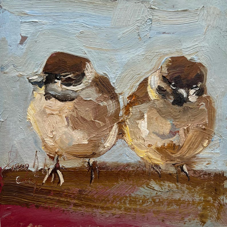 Puede incluir: Una pintura al &oacute;leo sobre lienzo que muestra dos p&aacute;jaros peque&ntilde;os de color marr&oacute;n y blanco posados uno al lado del otro. Los p&aacute;jaros tienen cabezas de color marr&oacute;n oscuro, cuerpos de color marr&oacute;n claro y marcas blancas. El fondo es azul claro texturizado y la base es de color marr&oacute;n oscuro.