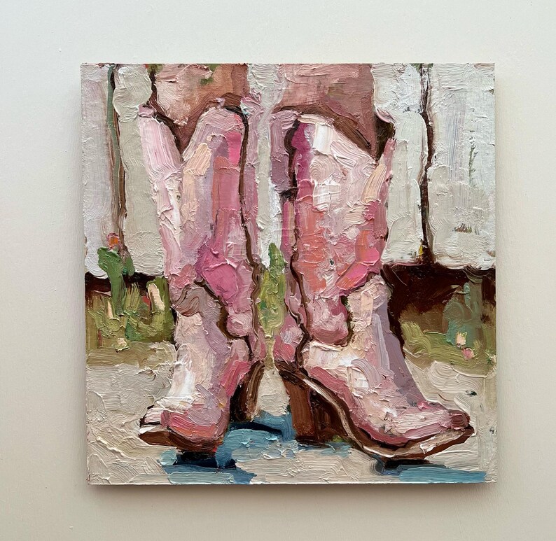 Puede incluir: Pintura al &oacute;leo de dos botas de vaquero rosas con tacones marrones. Las botas est&aacute;n pintadas con pinceladas gruesas, lo que les da una apariencia texturizada. El fondo presenta toques de verde y blanco, lo que sugiere un entorno al aire libre.