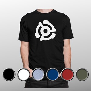 May include: Black t-shirt with a white graphic of a 45 RPM record adapter. The shirt is shown with colour swatches of black, white, light blue, dark blue, red, and olive green. The t-shirt has a classic crew neck.
