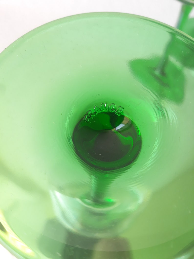 K&ouml;nnte beinhalten: Nahaufnahme des Bodens eines gr&uuml;nen Glasbechers mit der Aufschrift "FRANCE" am Boden.