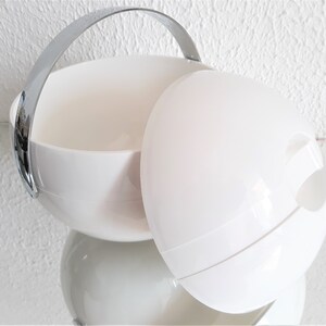 May include: White plastic ice bucket with a chrome handle and a separate lid. The lid has a cutout for easy access to ice.