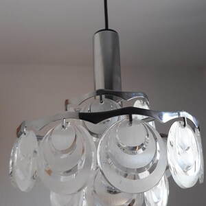 May include: A silver and clear glass pendant light fixture with multiple overlapping circular shades.