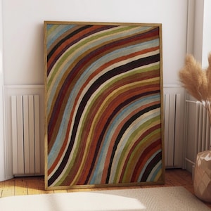 May include: A rectangular wall art piece featuring a series of curved, multi-colored stripes in shades of rust orange, olive green, light blue, and dark brown, all encased within a simple, light-toned wooden frame with a clean, flat profile.