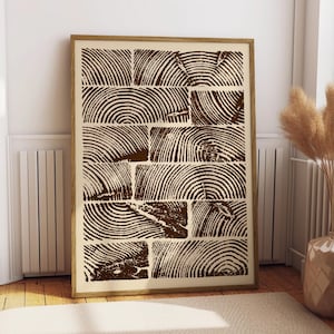 May include: A framed art print featuring a brown and cream-colored wood grain pattern. The artwork showcases a series of rectangular blocks with detailed concentric circles, creating a rustic and natural aesthetic. The print is displayed in a room with a neutral color palette.