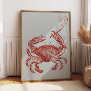 May include: A framed art print featuring a red crab smoking a cigarette. The crab is the central focus, rendered in a vintage style against a light blue background. The artwork is encased in a wooden frame, adding a touch of rustic charm.