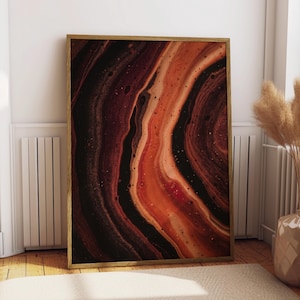 May include: A rectangular wall art print featuring an abstract fluid acrylic pour design with swirling layers of deep black, dark brown, and vibrant burnt orange tones, encased in a thin, light-colored wooden frame.