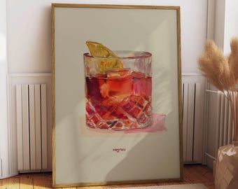 Puede incluir: Impresión en acuarela enmarcada de un cóctel Negroni. La bebida, de color rojo intenso, está en un vaso tallado con hielo y una rodaja de naranja. La palabra "negroni" está escrita en la parte inferior. El marco es de madera.