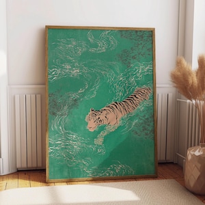 以下が含まれることがあります： 水色の水の中を泳ぐトラを描いた、額装されたアートプリント。トラは黒い縞模様とタン色の体をしている。水面には白い渦と濃い灰色の斑点がある。フレームは明るい茶色です。