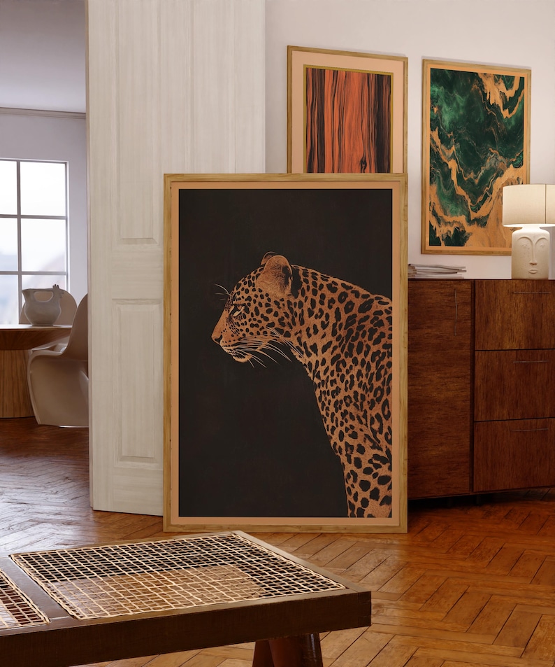 May include: A framed print of a leopard in profile against a black background. The leopard is brown and gold with black spots. The frame is a light wood color.