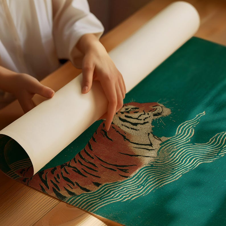 May include: A rolled-up print featuring a tiger design is being unrolled. The tiger is depicted in shades of brown and tan against a teal background with white wave-like patterns. The print is on a wooden surface.