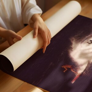 May include: A person unrolling a large print of a surfer riding a wave. The print is dark blue and white with a silhouette of the surfer.
