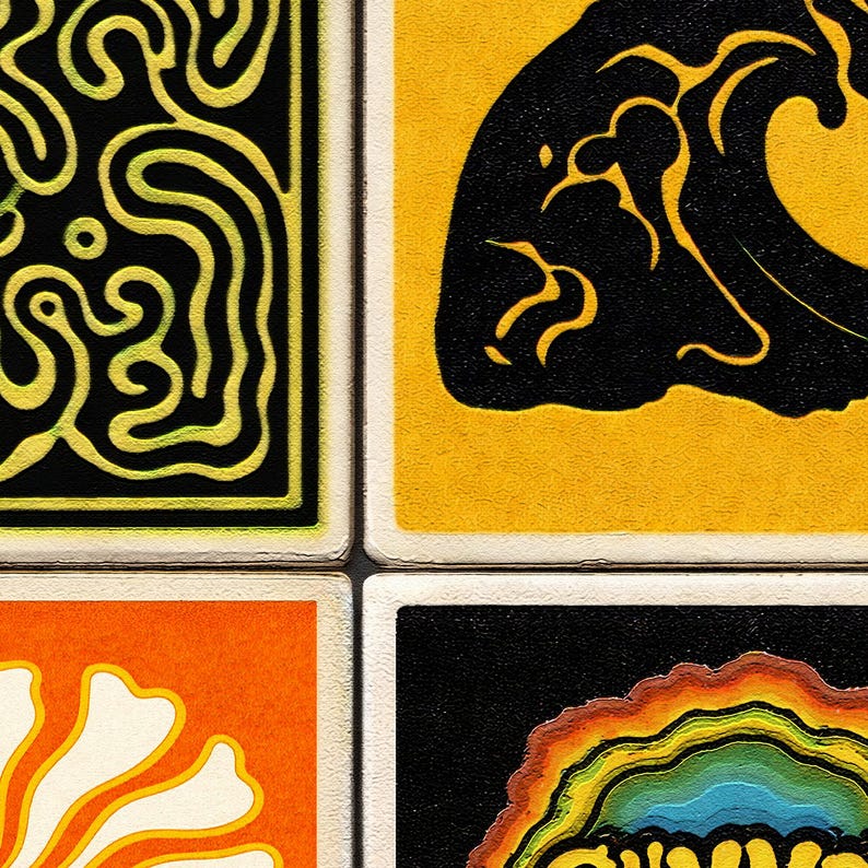 May include: A close-up of four square art prints. Each print features a unique design in bold colors: black and yellow swirls, a black wave on yellow, an orange floral shape, and a rainbow-colored design on black.