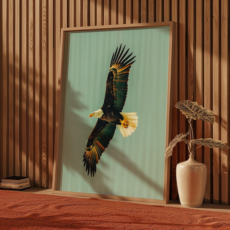 Pu&ograve; includere: Stampa artistica incorniciata con un'illustrazione dettagliata di un'aquila calva in volo. L'aquila ha piume marroni, bianche e gialle, su uno sfondo azzurro. L'opera d'arte &egrave; presentata in una cornice di legno, aggiungendo un tocco naturale.