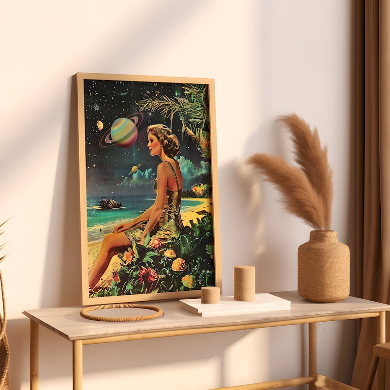 May include: A framed print of a woman sitting on a tropical beach with a large planet in the sky. The woman is wearing a gold dress and has long brown hair. The beach is surrounded by lush green foliage.