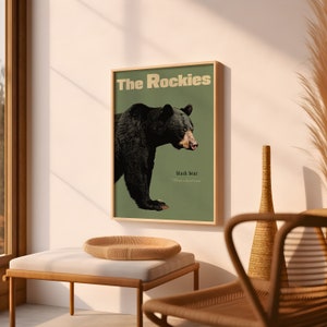 Pode incluir: Um p&ocirc;ster de estilo vintage com fundo verde que apresenta um urso preto com o texto "The Rockies" e "black bear" em uma fonte bege.