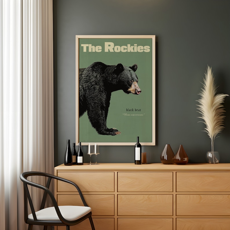 Pode incluir: Um p&ocirc;ster de estilo vintage com fundo verde que apresenta um urso preto com o texto "The Rockies" e "black bear" em uma moldura marrom.