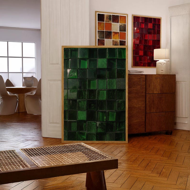 May include: A modern interior featuring framed art pieces. A large, framed artwork with a green, textured, square pattern is the focal point. Other framed pieces display red and orange square patterns. A wooden cabinet and table are also visible.